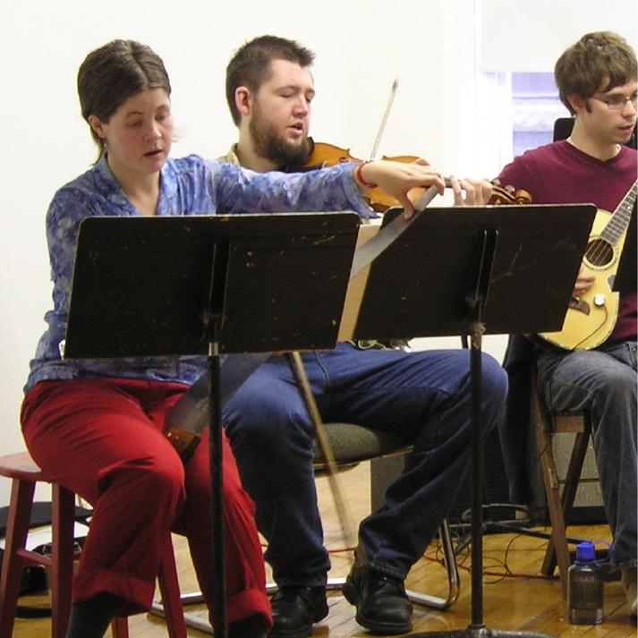 Trio performing, violin and guitar
